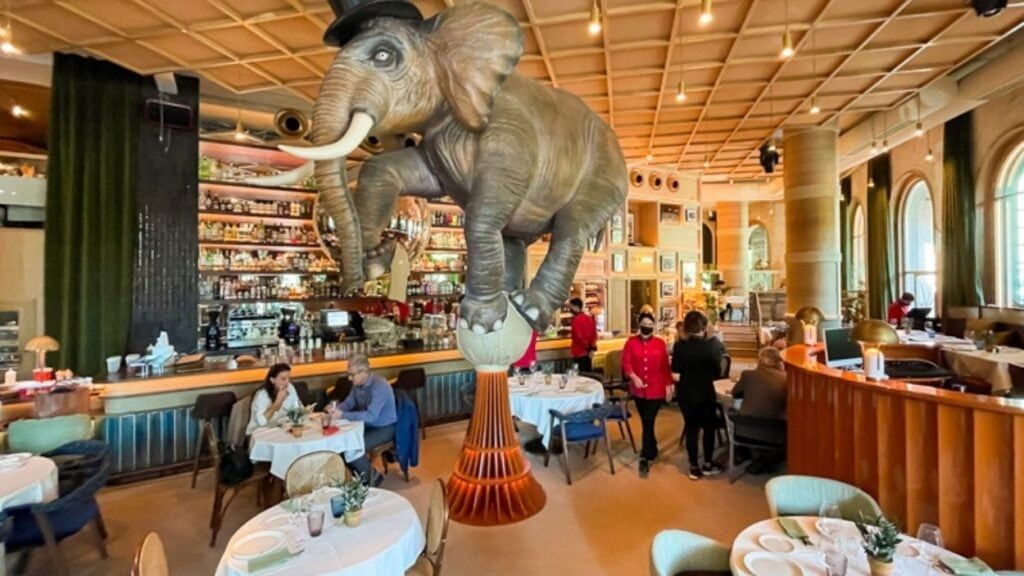 Elefante decorativo gigante en interior de restaurante alegre.