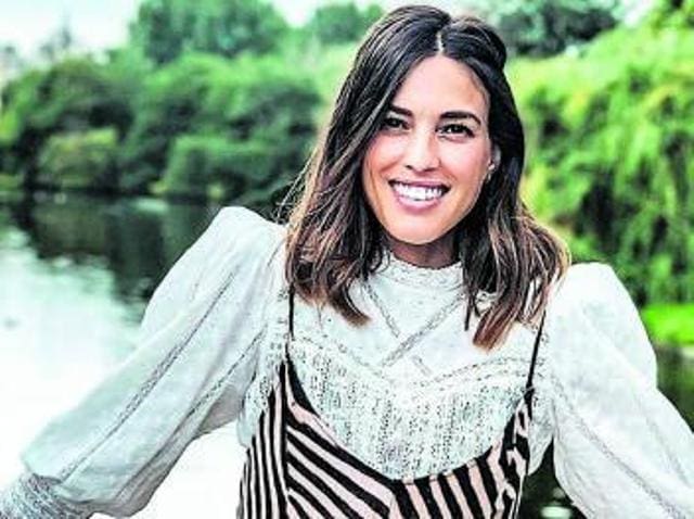 Vibras en corte mujer con estilo, sonriendo en un entorno natural junto al río.