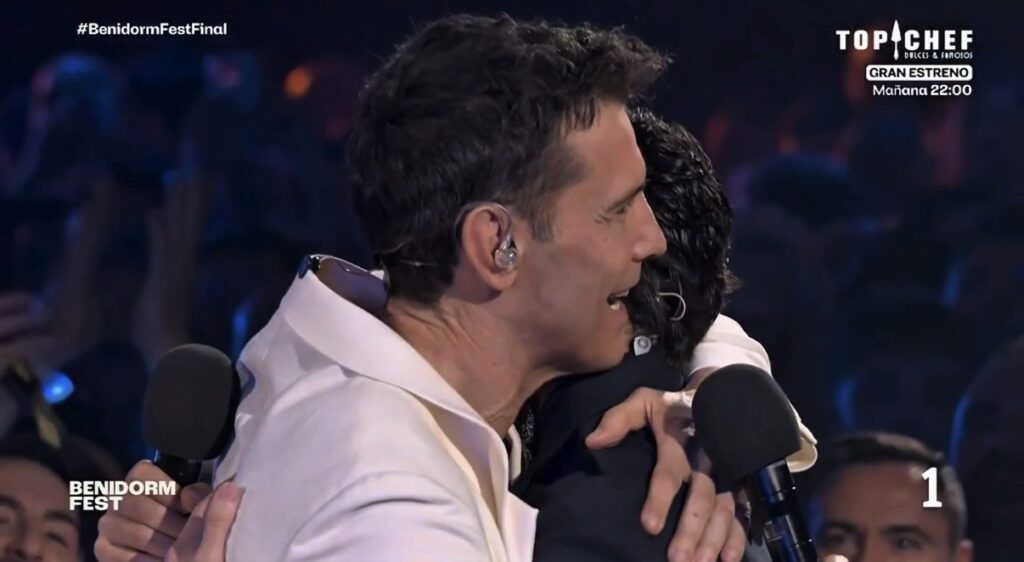 Emotivo abrazo entre Javier Ambrossi y Jesús Vázquez en el evento Vibras en corte, capturando la adm.