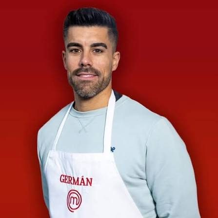 Germán posa con el delantal de MasterChef sobre fondo rojo en su foto oficial de concursante