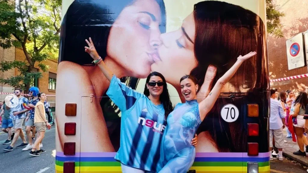Dulceida y Alba Paul bromean ante la cámara junto al autobús decorado con dos mujeres besándose